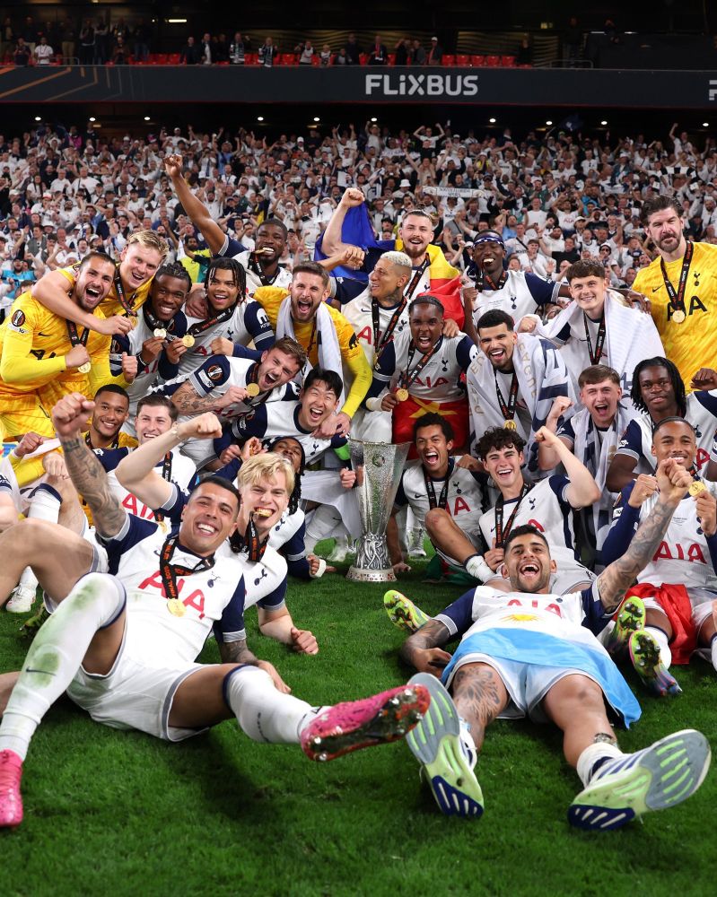 The Tottenham Hotspur team posing around the trophy in celebration.