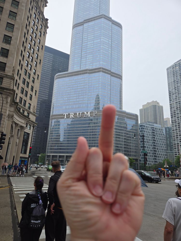 Woman holding middle finger up towards Trump Tower Chicago 
