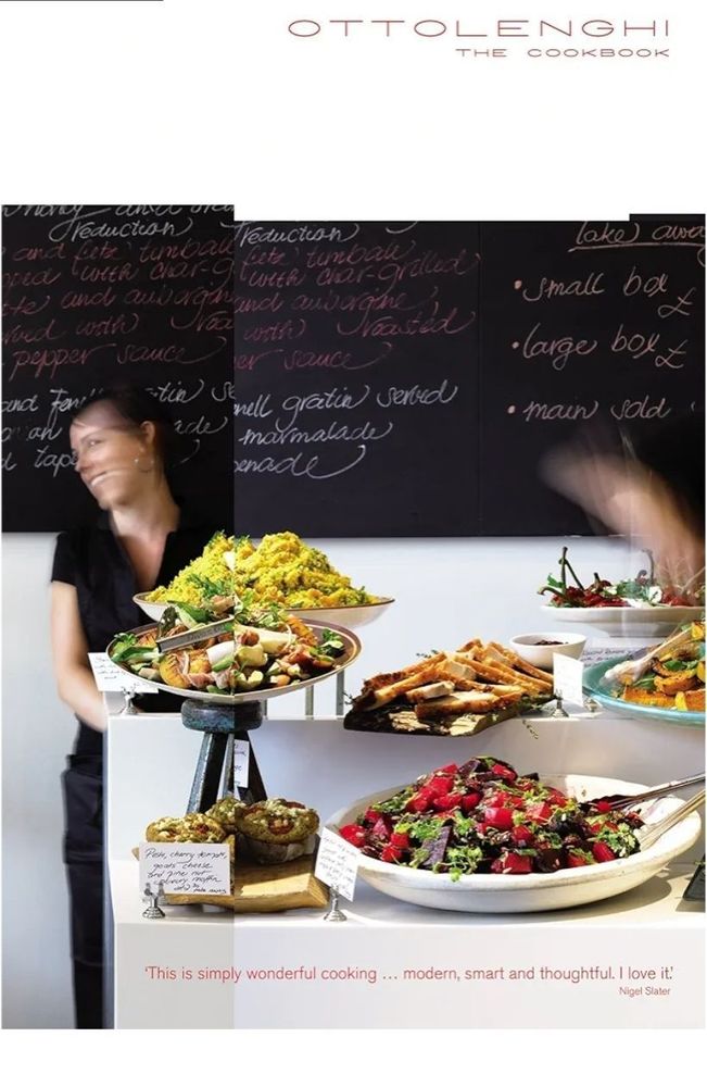 The picture shows the cover of the cookbook Ottolenghi by Yottam Ottolenghi and Sami Tamimi. The cover is a stylised picture of food on platters in the restaurant in front of a chalk board with one of the waitresses. 