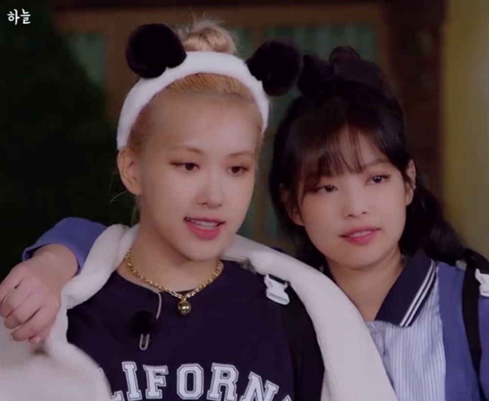 a girl wearing a headband with panda ears is standing next to a girl wearing a california shirt