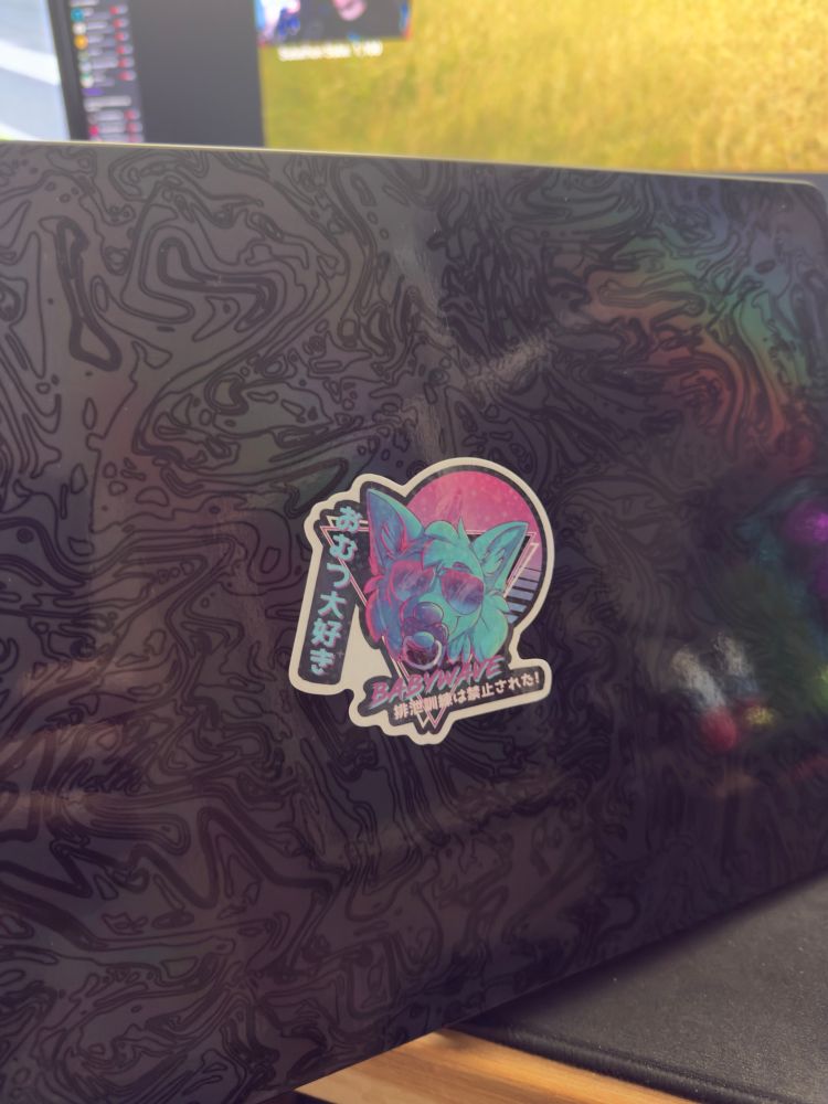 Laptop with baby wave sticker applied on top of skin.