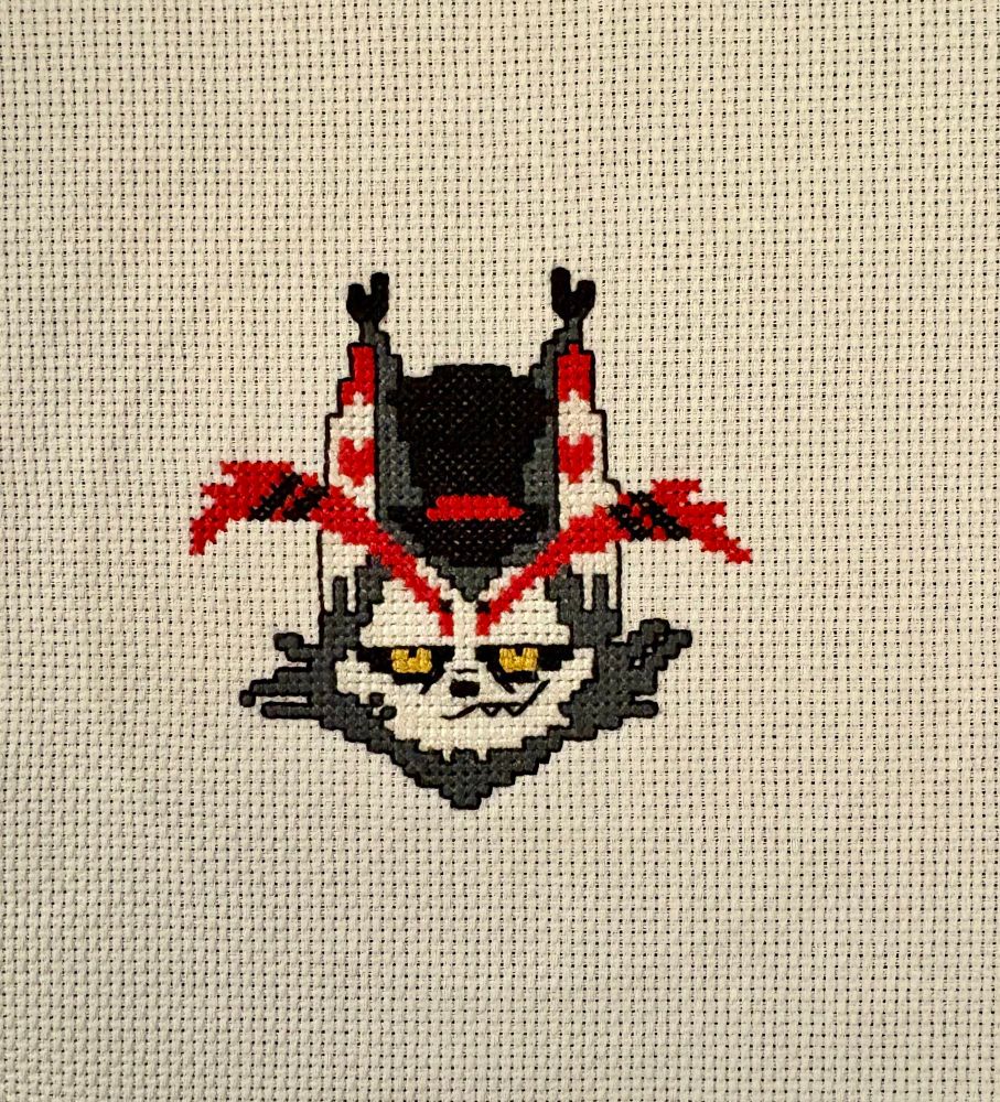 A cross stitch of Husker’s face from Hazbin Hotel. He’s smirking. It’s on white fabric. 