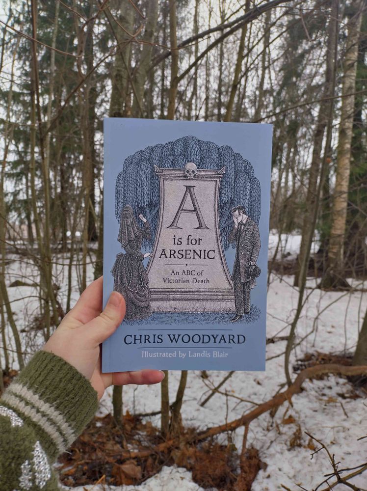 Cover of A is for Arsenic. Photo taken in my backyard. Remnants of snow and trees in the background.