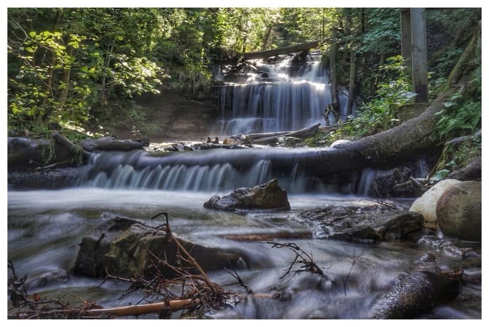 Flowing waterfall surrounded by a forest of green
