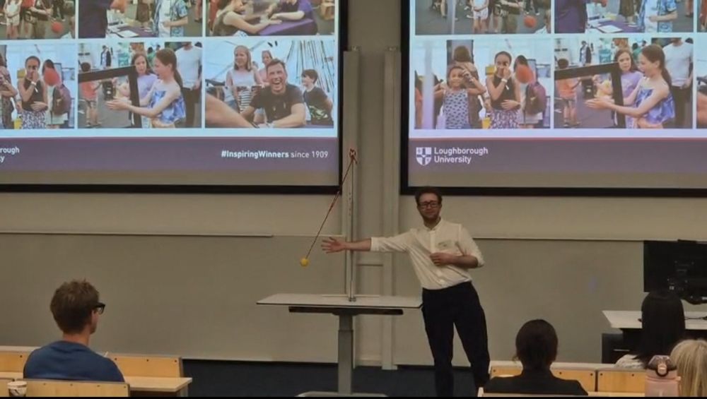 Oscar demonstrating the Pulfrich illusion - a stand with a ball swinging as a pendulum. Behind, the slide shows pictures of demonstrating body illusions at a science festival with smiling and laughing attendees.
