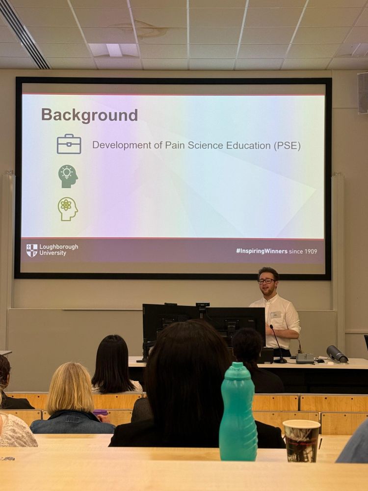 Oscar presenting a slide entitled background - development of pain science education