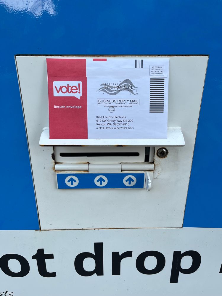 An election ballot being placed in a drop box for the King County primary elections.