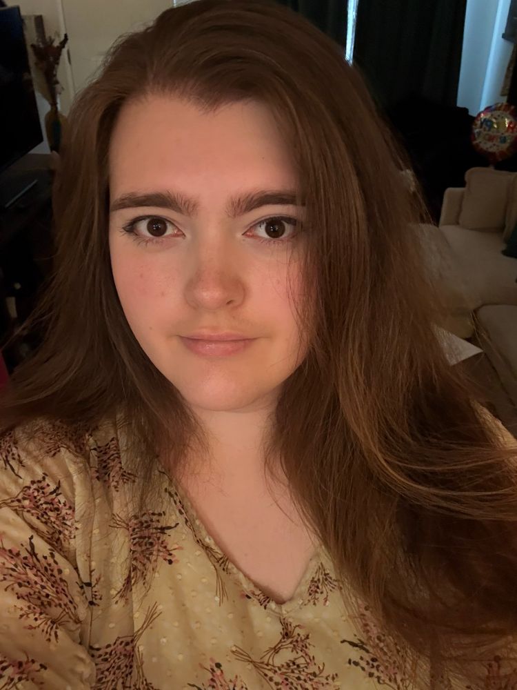 a selfie of violet with her long brown hair down wearing a yellow flowery top. her eyeliner is pretty good but not perfect but its good enough for a pfp if she does say so herself