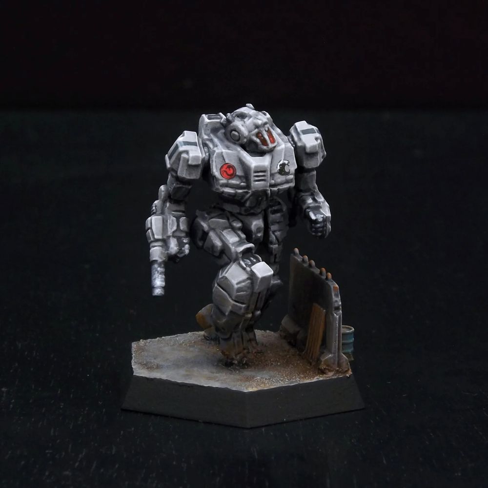 A painted miniature of a Wasp 'Mech.  It is light ash gray, and the cockpit glass is dark red.  It is posed as if dashing.  It is next to a knee-high gray concrete wall.  The dragon emblem of the Draconis Combine is on its right torso.  The emblem of the Genyosha, a black wave, is on the left torso.  Thin black stripes decorate its shoulders. 