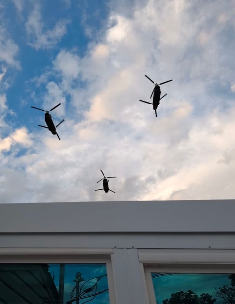 Three huge Chinook helicopters fly over a house in Denver 