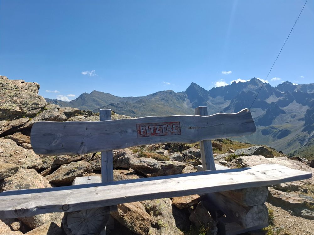 Holzbank mit Schriftzug "Pitztal" vor einer Bergkulisse
