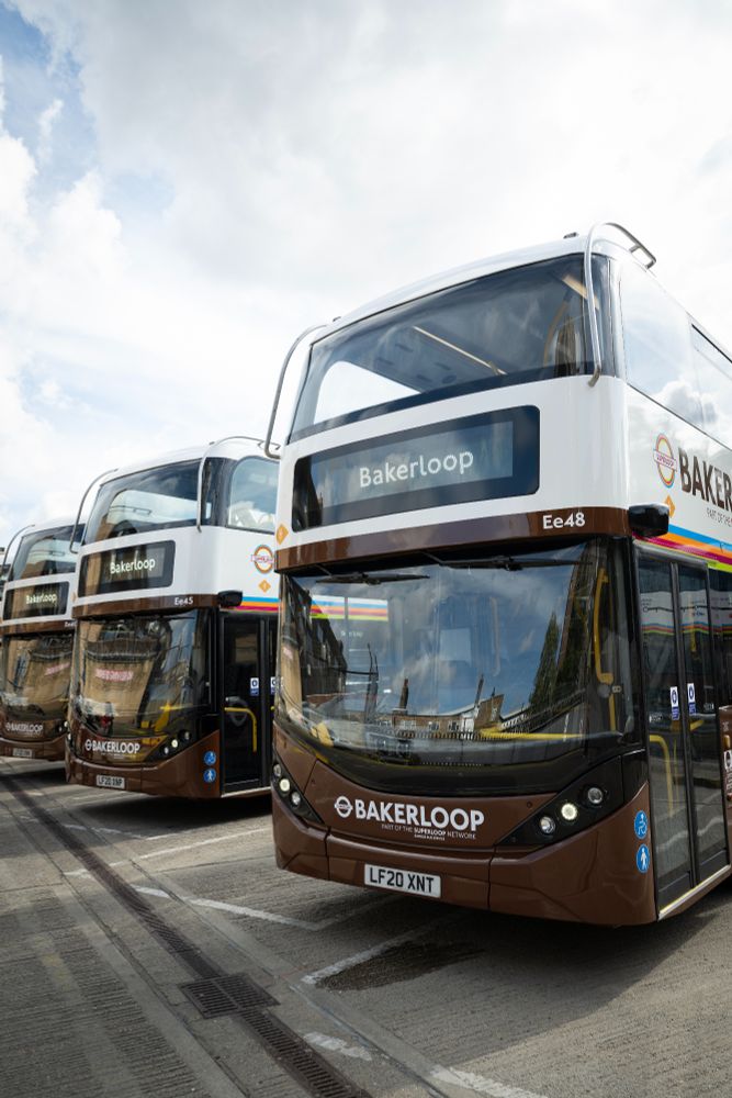 Five brown TfL double-decker buses displaying “Bakerloop” signage - parked in a row.