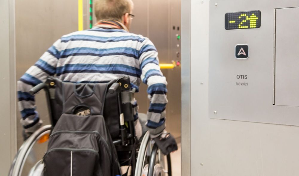 A man in a wheelchair entering a lift.