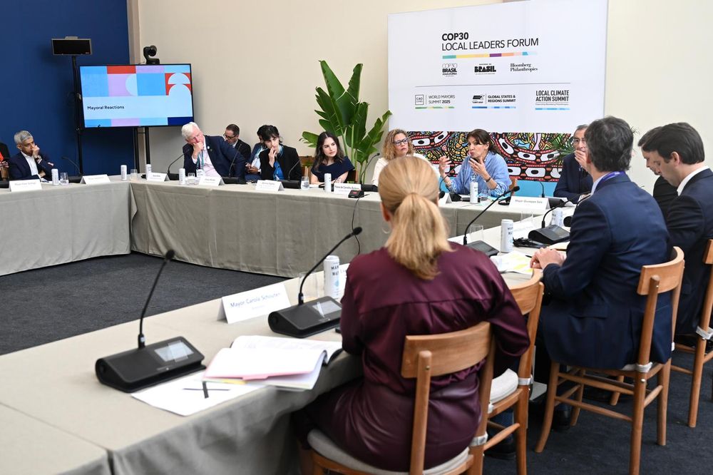 A wide shot of the Mayoral Disinformation Masterclass at the C40 World Mayors Summit, showing the Mayor of London and other mayors seated around a large rectangular table in discussion.