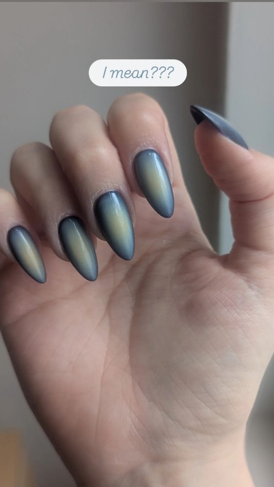 Syd's right hand showing off their new nails which ombre from navy to a sort of moldy yellow in the center.