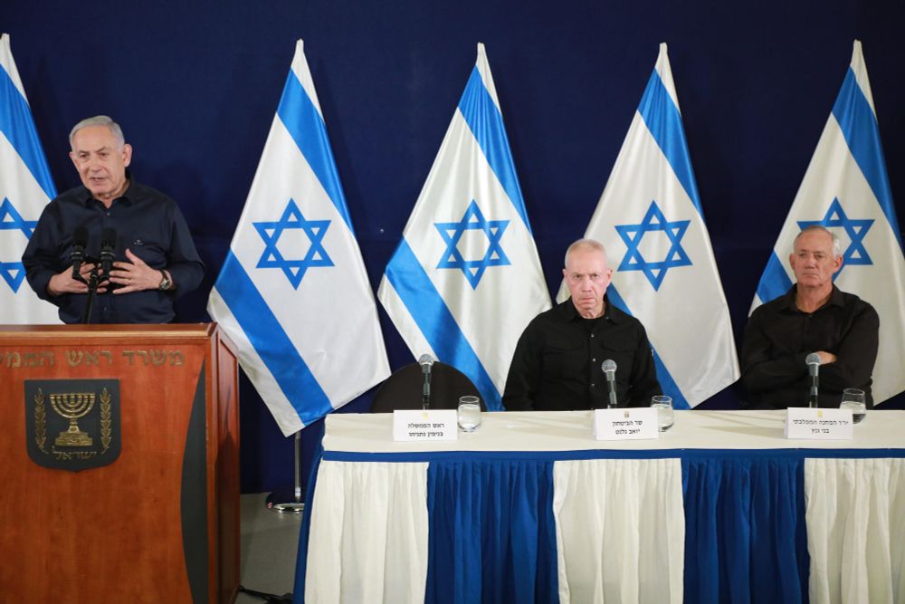 Benjamin Netanyahu, Benny Gantz, and Yoav Gallant at a press event, all in identical black shirts.