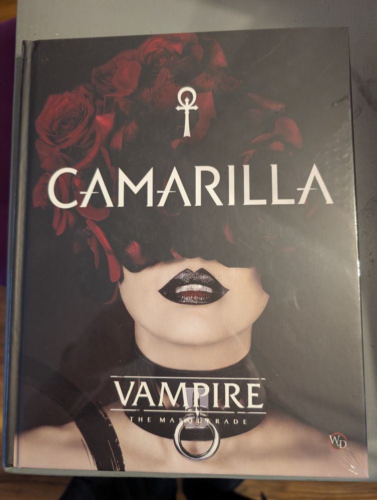 A photo of a shrink-wrapped copy of an RPG sourcebook. It is a copy of the Camarilla book for Vampire The Masquerade 5th Edition