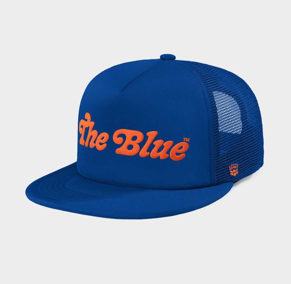 blue foam trucker hat with “the blue” in orange 80’s script