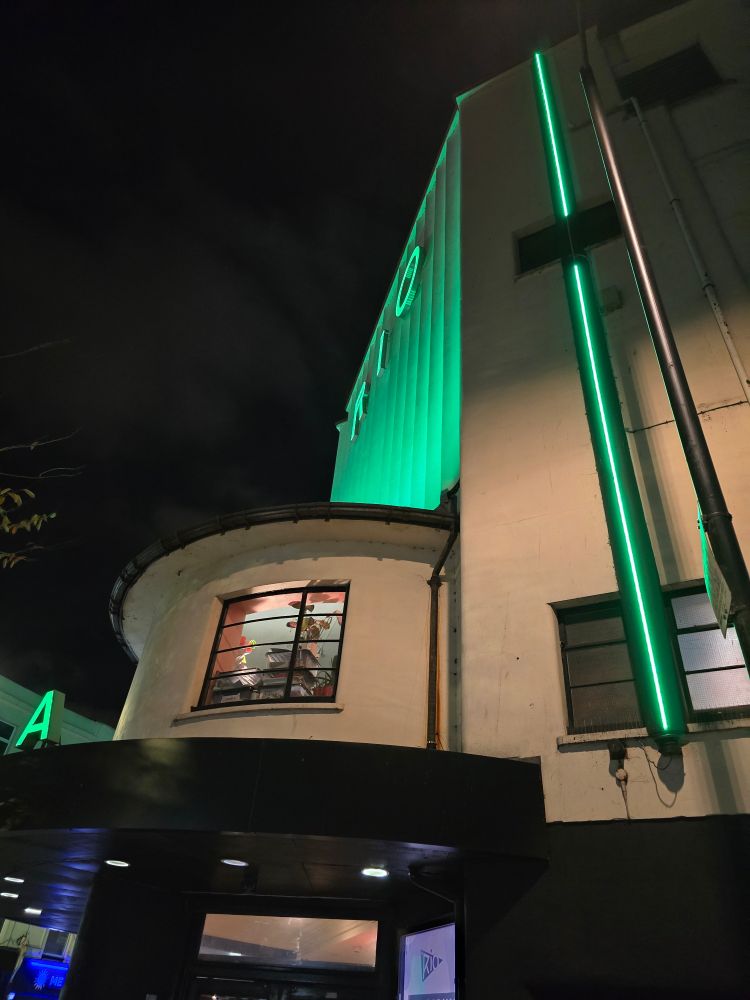 Rio Cinema in Dalston lit up in green light looking beautiful in the late evening. 