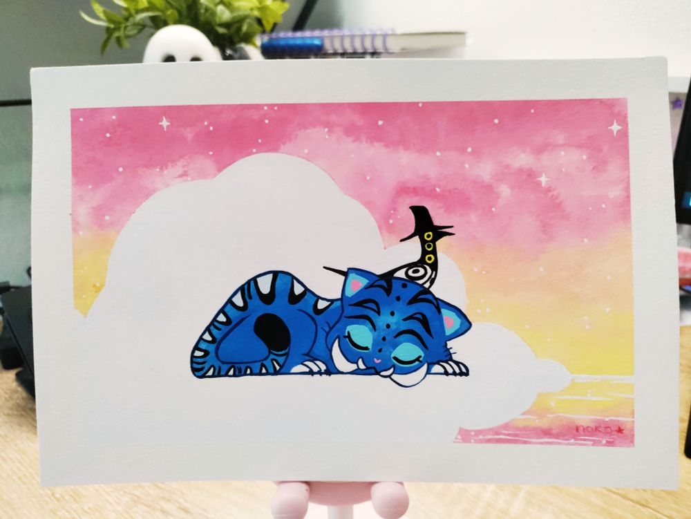 Photo de ma peinture sur feuille. 
On y voit un tigre bleu endormi, il a de grandes dents de sabres. Sur sa tête, il y a une pie noire et blanche à 3 yeux jaunes qui nous regarde. Elle porte un chapeau haut noir. 
En arrière plan, on aperçoit un ciel en dégradé de rose/jaune avec un gros nuage blanc là où se trouvent le tigre et la pie! 
Les deux personnages viennent du film d'animation Kpop Demon Hunters 