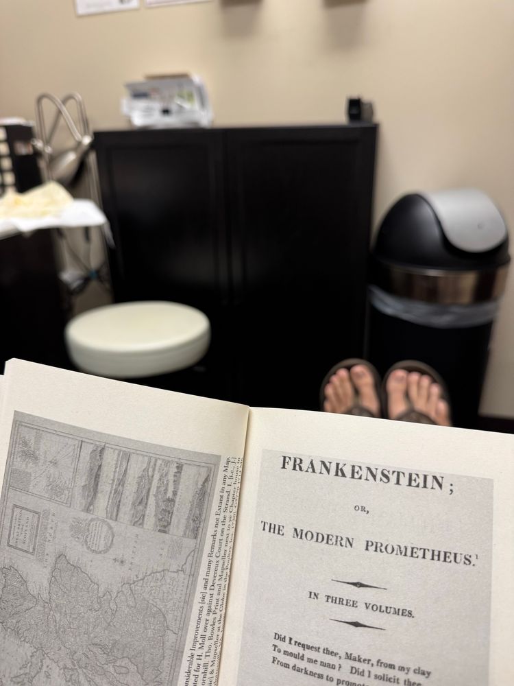 In a doctor’s office reading Frankenstein.