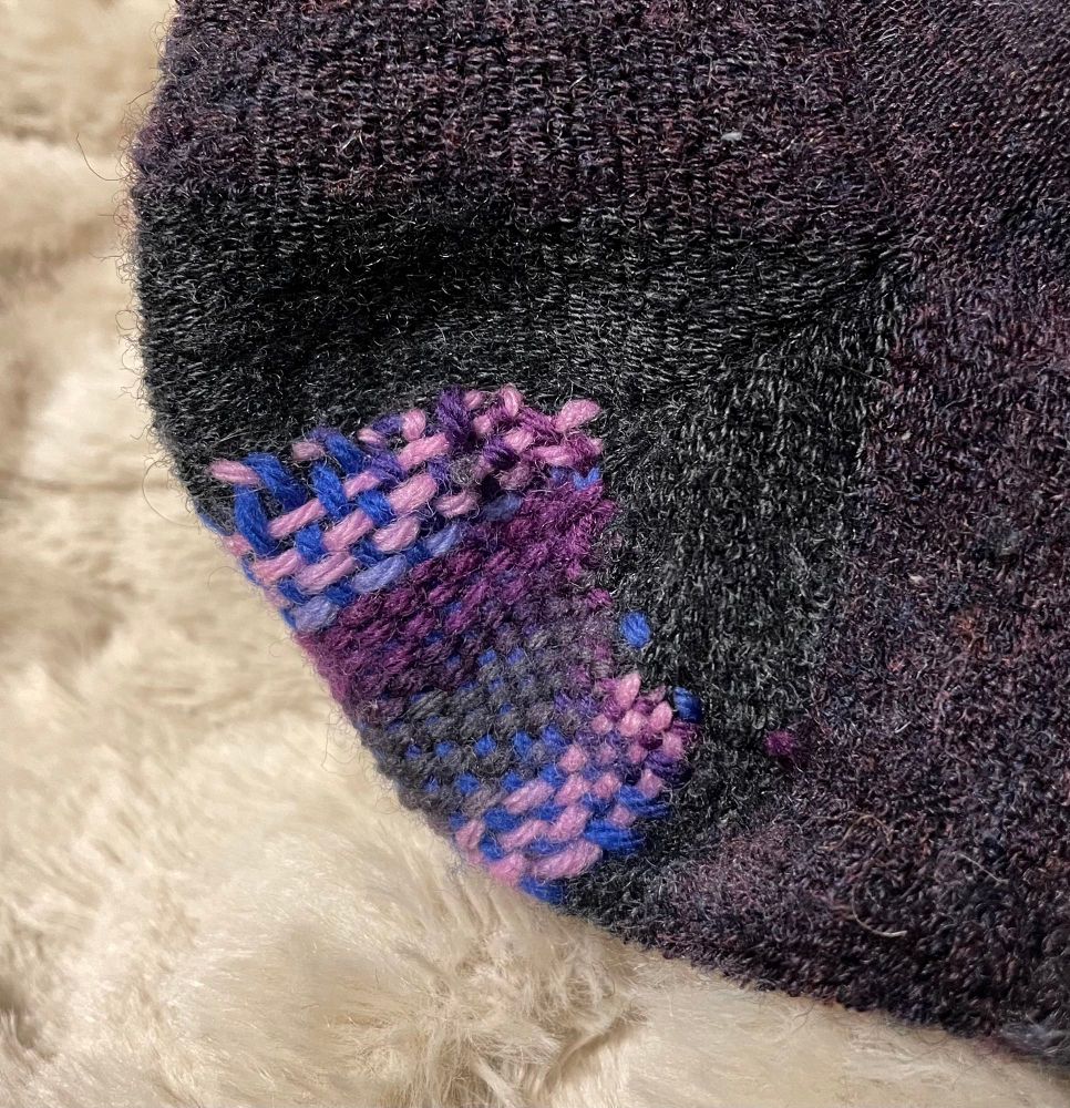 Side angle— finished woven patch on the heel of a sock