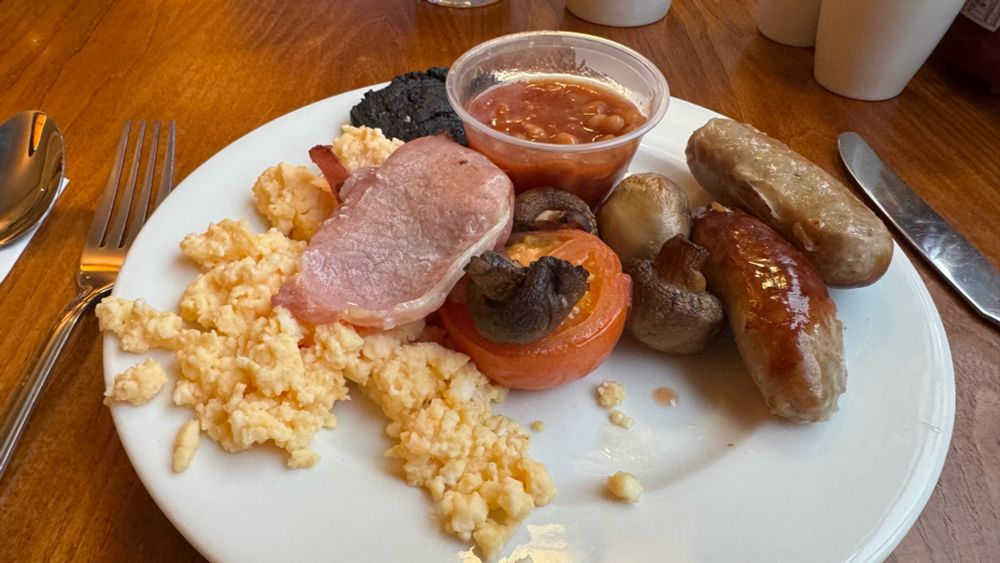 PremierInn breakfast on a plate. Sausage, bacon, scrambled eggs, tomato, beans and black pudding.