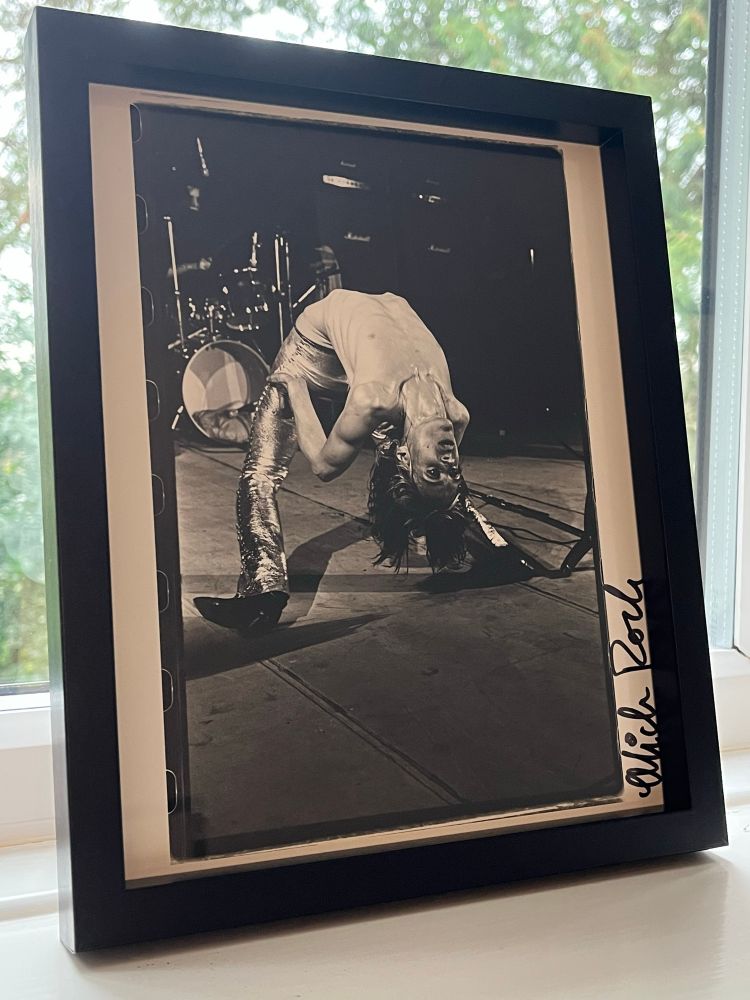 Print of an iconic photograph of Iggy Pop fronting The Stooges doing the “backbend” , taken and signed by esteemed music photographer Mick Rock