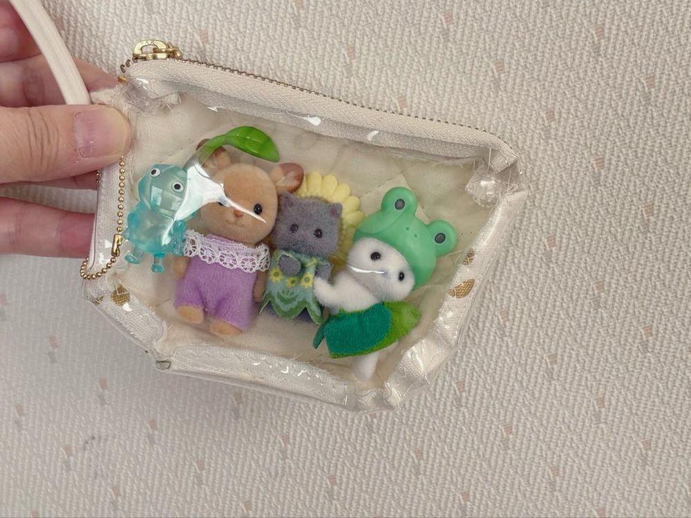 ポーチにシルバニアのシカの赤ちゃんとペルシャネコの小さい赤ちゃん、アザラシの赤ちゃんと氷ピクミンが入った写真