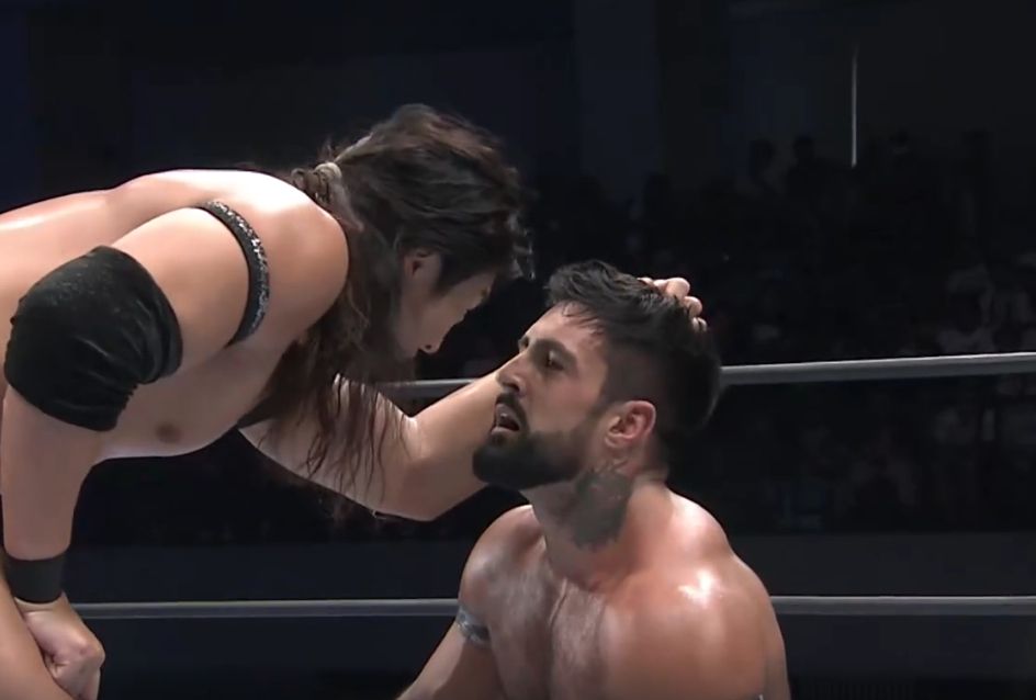 Konosuke Takeshita has a hold of Drilla Moloney's hair and is yelling at him about Gabe Kidd. Drilla Moloney is on his knees and looks at Takeshita's lips like he's seen god.