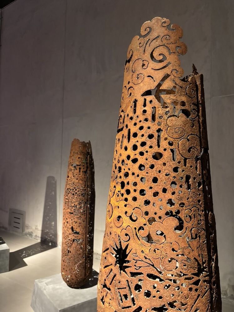 Bomb casings carved with images of planes dropping bombs on Laotian villages
