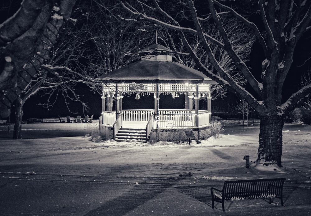 A gazebo in a snow covered park 
