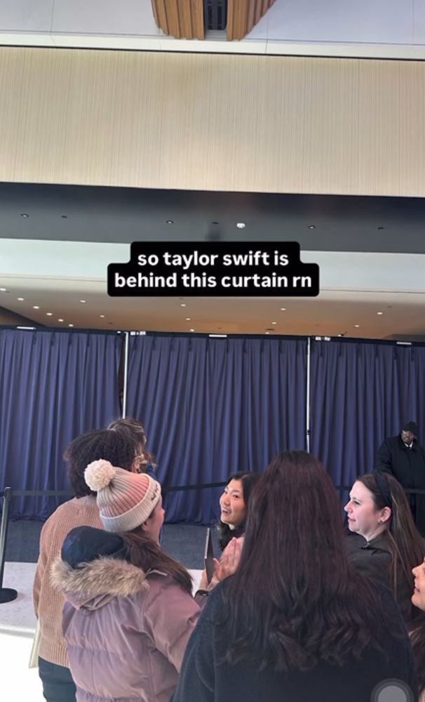 Photo of people in front of blue curtain

white text against black backgrounds: “so taylor swift is behind this curtain rn”