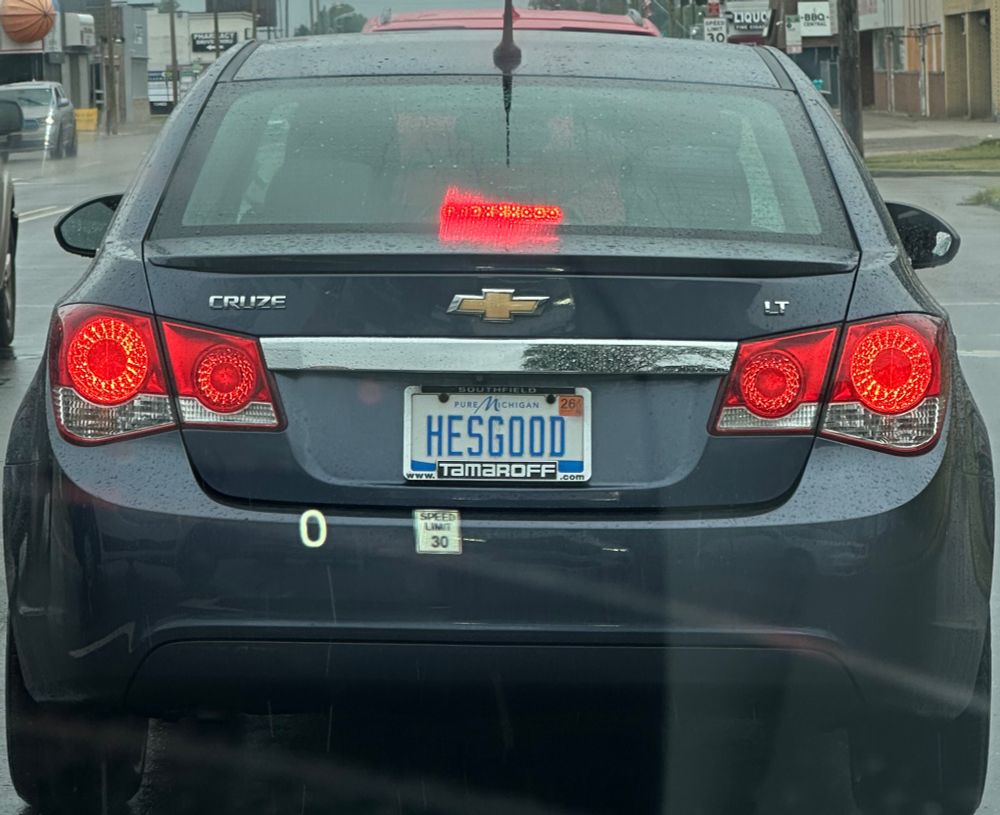 A dark gray Chevy Cruze with the license plate HESGOOD