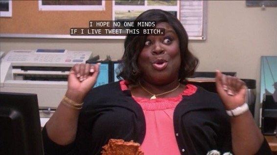 Retta (Donna Meagle) from the show Parks and Rec saying “I HOPE NO ONE MINDS IF I LIVE TWEET THIS BITCH.”
She is a black woman in an office with a fax machine behind her. She is wearing a salmon colored blouse with a black cardigan. 