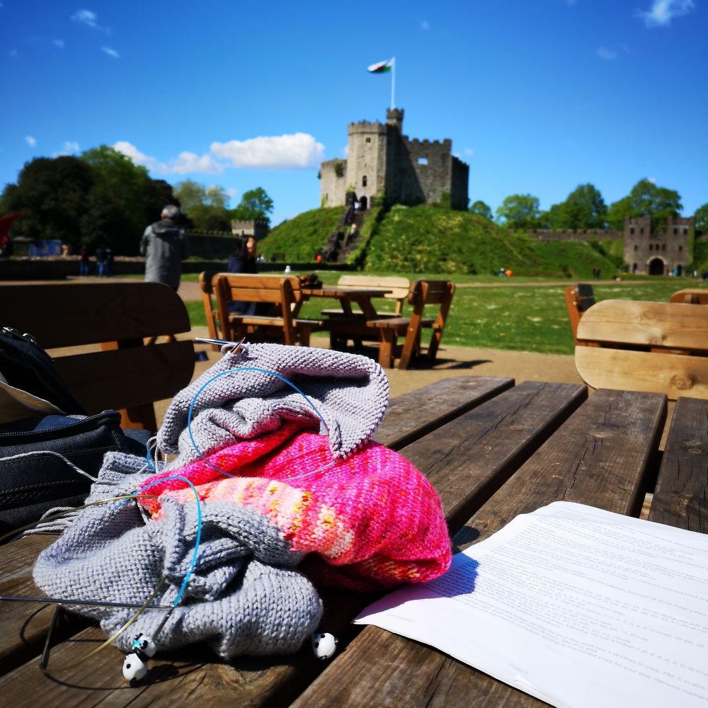 a knitting WIP on a picnic table with Cardiff Castle in the background
