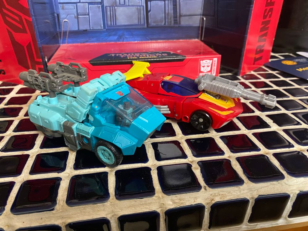 Two cars side by side one is red one is blue