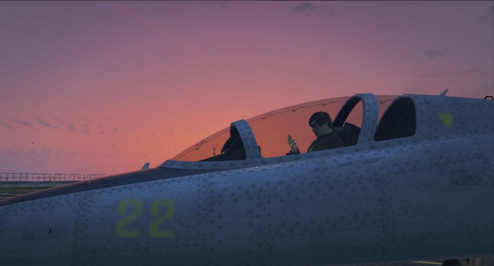 A male video game character sitting in a light-grey fighter jet looking at their phone. The sun has just set in the picture. 