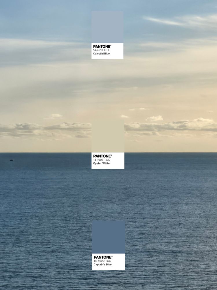 Picture of a muted navy blue sea and a fluffy cream and light blue sky