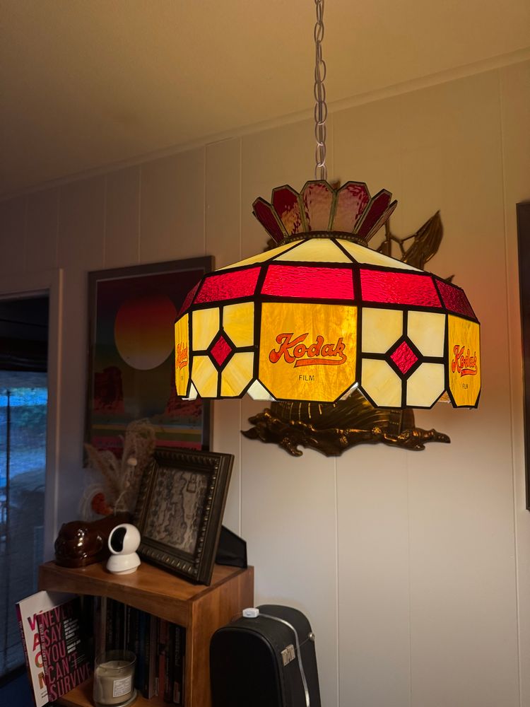 A very vintage stained glass lamp like you used to see in bars and pool halls. It's yellow, cream and red glass with Kodal Film branding on every other pane