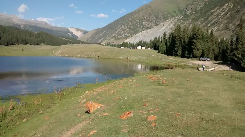 Mountains in the background. In the foreground a lake, bound by a scarp. 