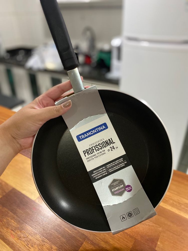 mão segurando um modelo de frigideira antiaderente da tramontina de 24cm 