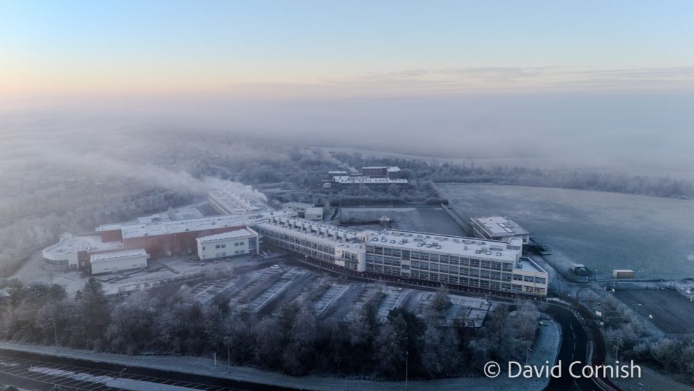 Aerial photograph of a large school building shrouded in fog.