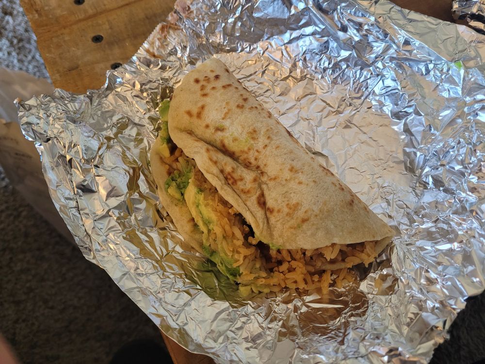 Pictured: a bean, rice, and avocado taco on a flour tortilla.