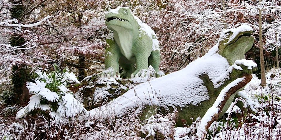 colour photo of the two Crystal Palace Iguanodons. snow has dusted them, and the surrounding landscape. this image is on the Eventbrite page, and I do not know it's origin or who to credit - apologies