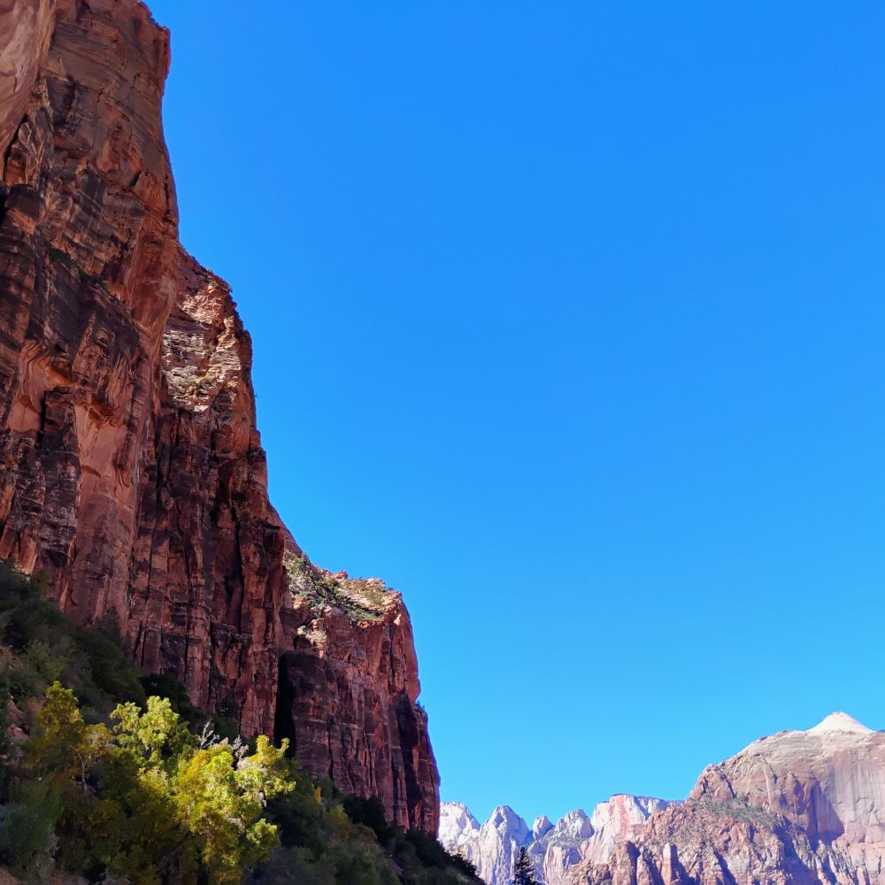 Photo contrasting the shaded reddish colored rocks in the foreground with the larger lighter color mountains fading into the distance