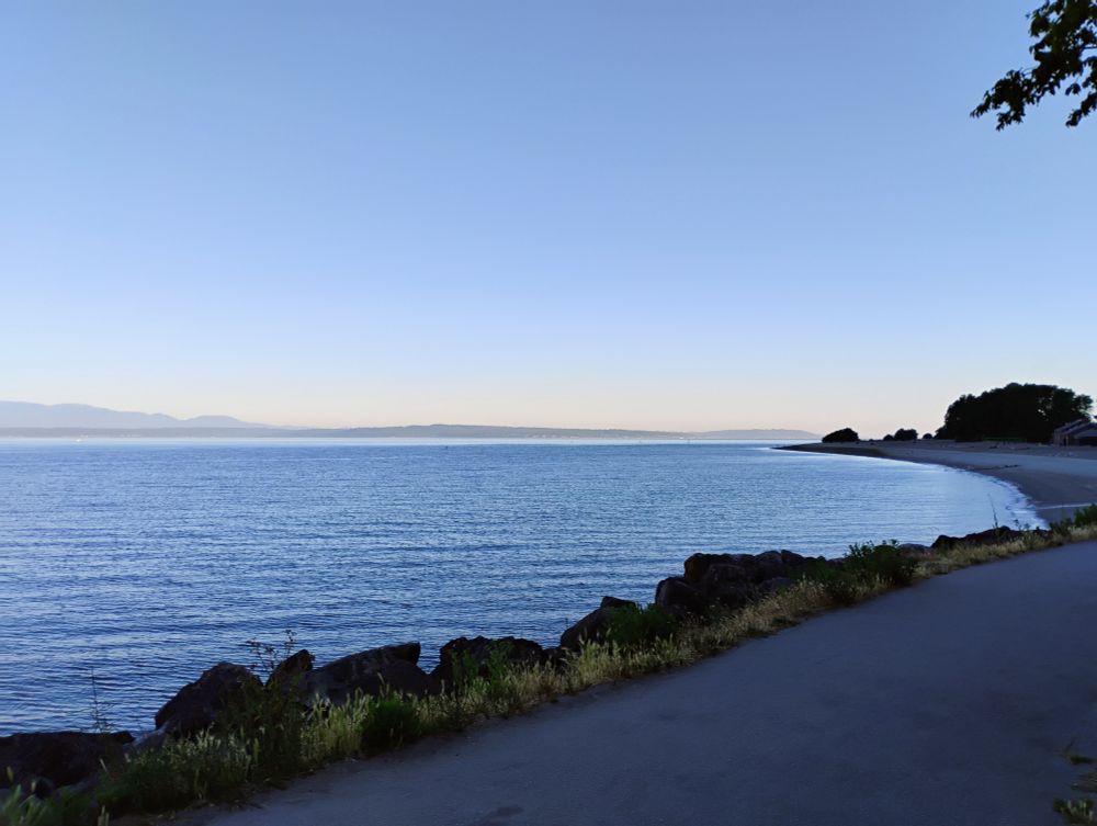 Photo (3 of 3 pano shot) of view from Golden Gardens park in Seattle, overlooking the water with blue skies in the distance