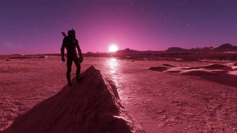 elite dangerous screenshot  - picture of a  Cmdr on top of a rock mound looking a sunrise in a pink and purple sky