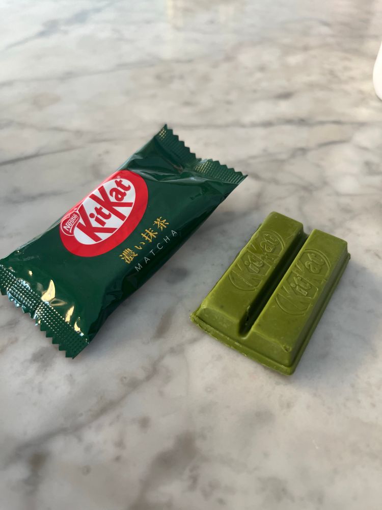 Doppia barretta di KitKat verde al matcha 🍵, accanto al suo involucro.