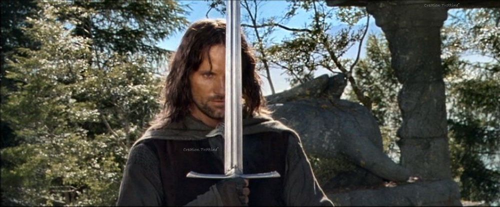 A picture of Aragorn, a white male with brown hair in dark clothing and a cape, holding a sword in front of him as he prepares to fight a battalion of Uruk-Hai warriors at Amon Hen in 2001's Lord of the Rings: The Fellowship of the Ring